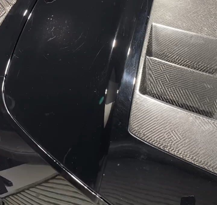The same black panel with a deep clear gloss after paint correction