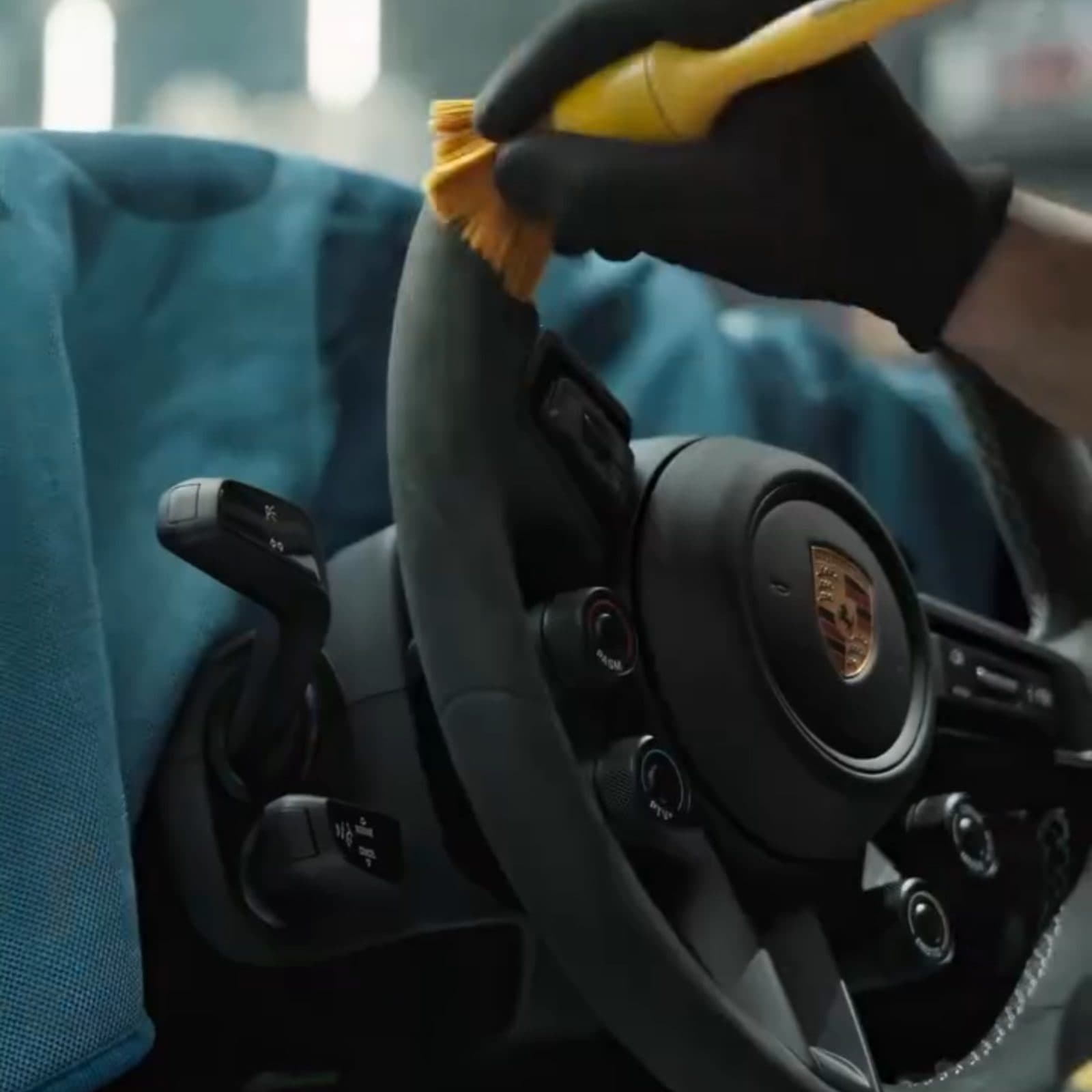 Steering wheel being cleaned with a soft detailing brush